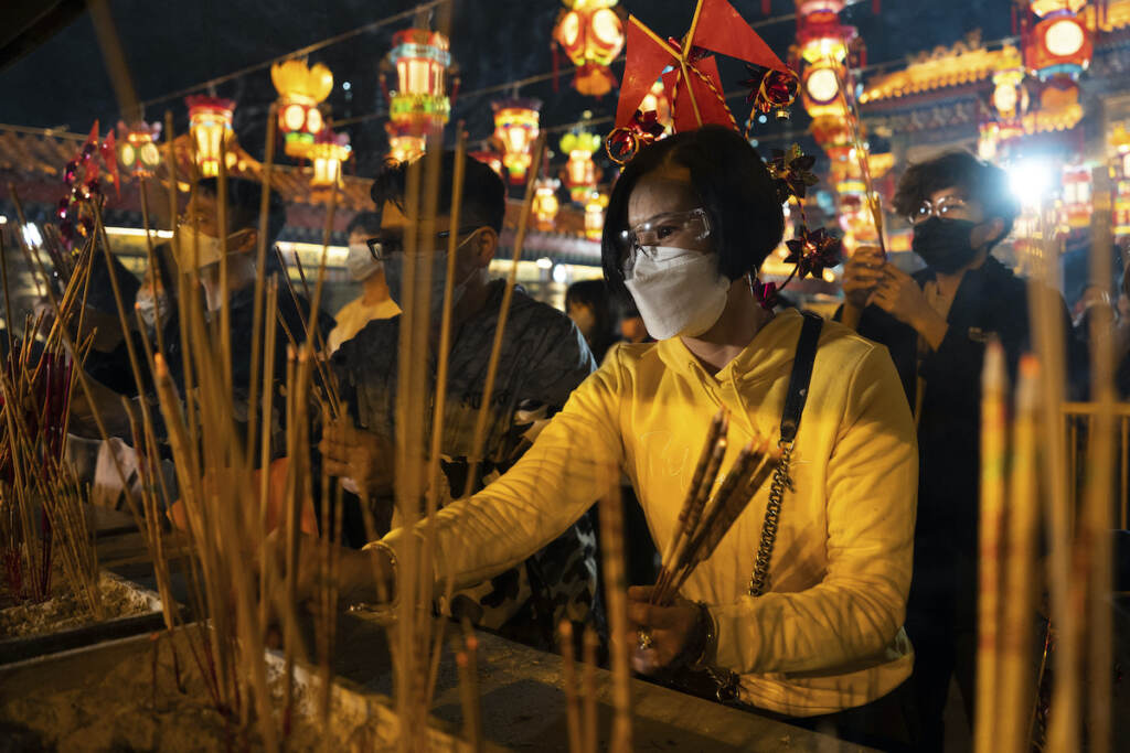 Hong Kong Lunar New Year Worshippers wearing face masks burn their first joss sticks as they offer prayer at the Wong Tai Sin Temple, Saturday, Jan. 21, 2023, in Hong Kong