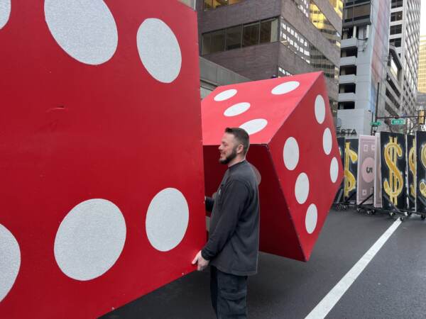 James Holden of the Greater Kensington String Band positions a pair of dice for their Monopoly themed performance (Jonathan Wilson for WHYY)