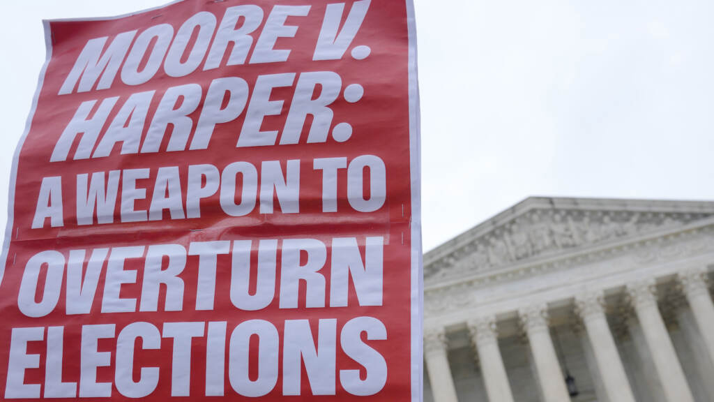 A sign held up by a demonstrator says “MOORE V. HARPER: A WEAPON TO OVERTURN ELECTIONS” at a December rally outside the Supreme Court in Washington, D.C. A Demonstrator holds a sign during a rally in front of the Supreme Court, Wednesday, Dec. 7, 2022, on Capitol Hill in Washington.