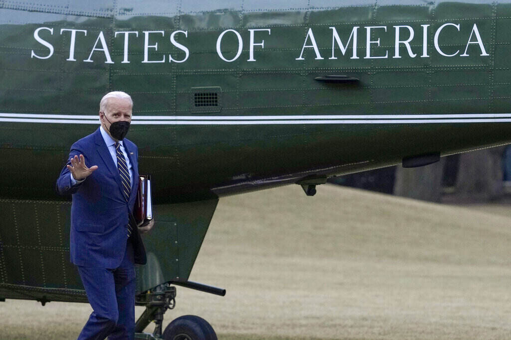 Biden President Biden waves while walking towards a plane.