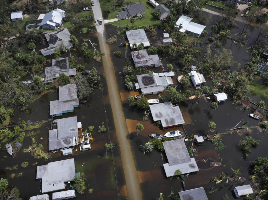 An aerial view of a row of homes and flooded streets.