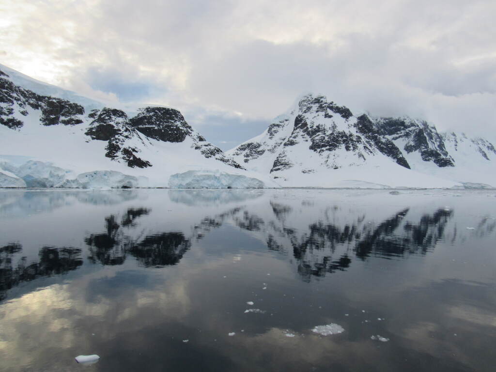 delaware-students-antartica-researcher-zoom-3 A snowcapped landscape is reflected in a body of water.