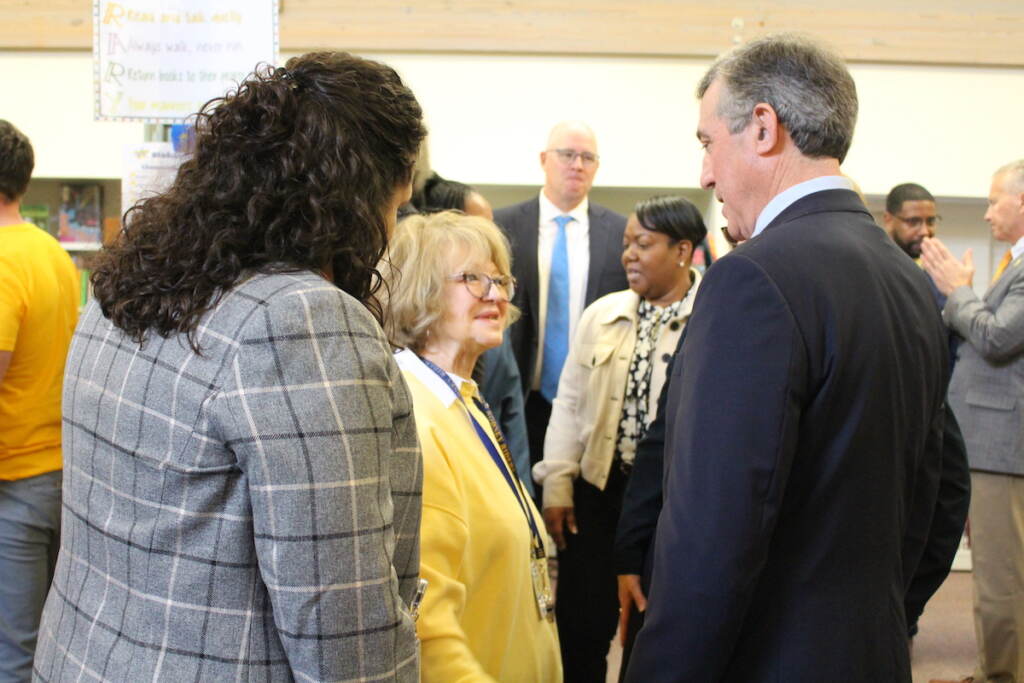 delaware-teacher-salary-raise Gov. Carney speaks with two other people.