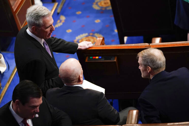 McCarthy stands with a group of people on the House floor.