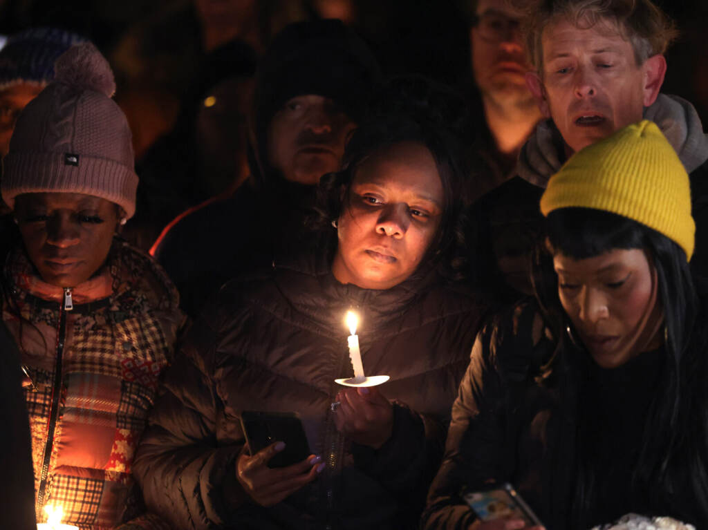 Memphis Awaits Release Of Police Body Cam Video Of Tyre Nichols’ Arrest Prior To His Death Days Later A candle lits a person's face in a group of mourners.