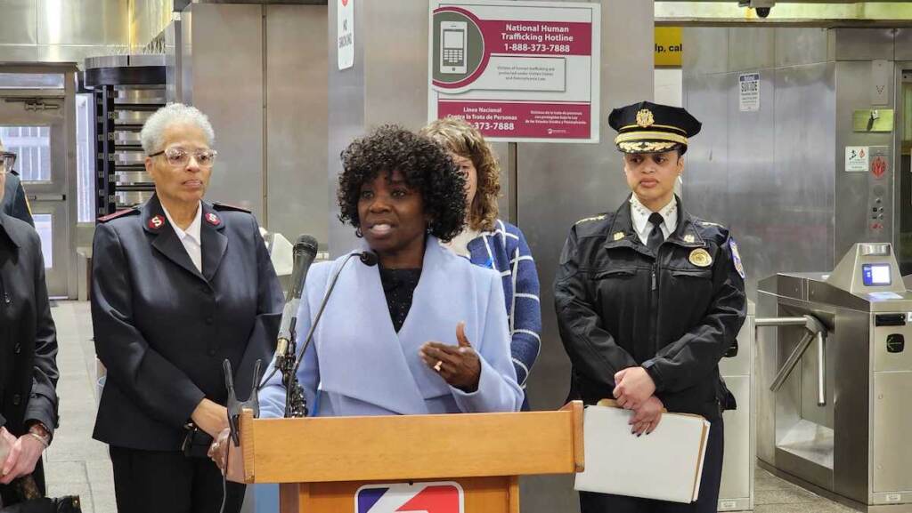 septa-human-trafficking-1 A person speaks at a podium in a SEPTA subway station.