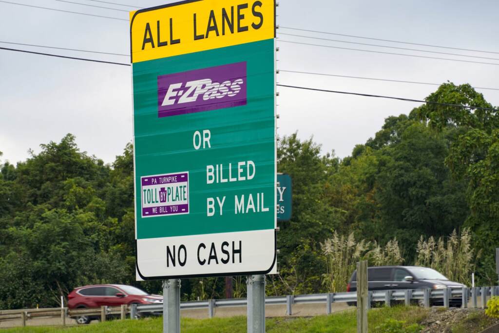 turnpike-20-1620×1080 A sign reads E-ZPass. The highway is visible in the background.
