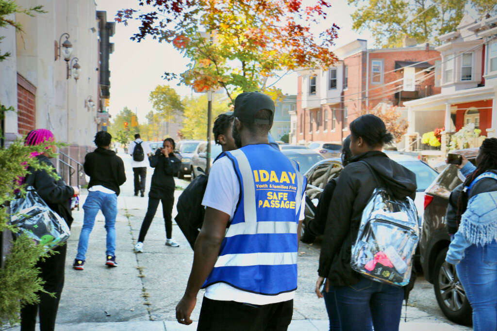 2022 10 07-e lee-malik smith-west philadelphia high school-safe passage scuffle Malik Smith, seen from behind wearing a safety vest, walks with a group of students.
