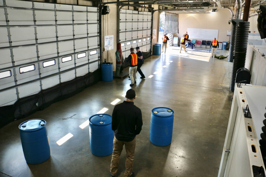An aerial view of police recruits training in a large space.