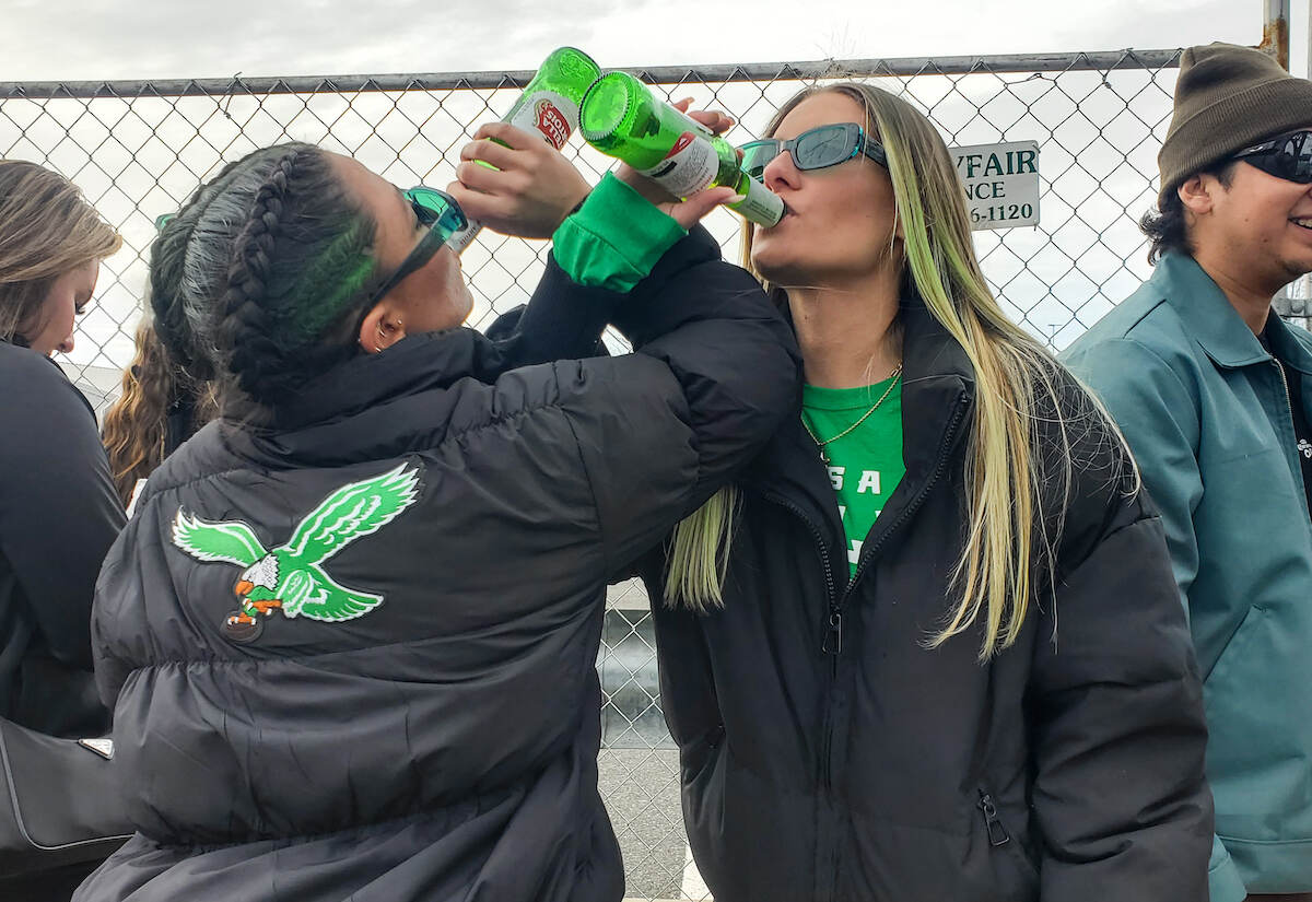 Danielle Walters (left) and Nicole Purcell spent an hour in line at Xfinity Live!, and have made the Eagles chant at least a dozen times with new friends they just met in line. ''It's been so lit. Everybody is coming together,'' Walters said. ''Philly is friends with everyone, but nobody is friends with Philly.'' (Emily Cohen for WHYY)