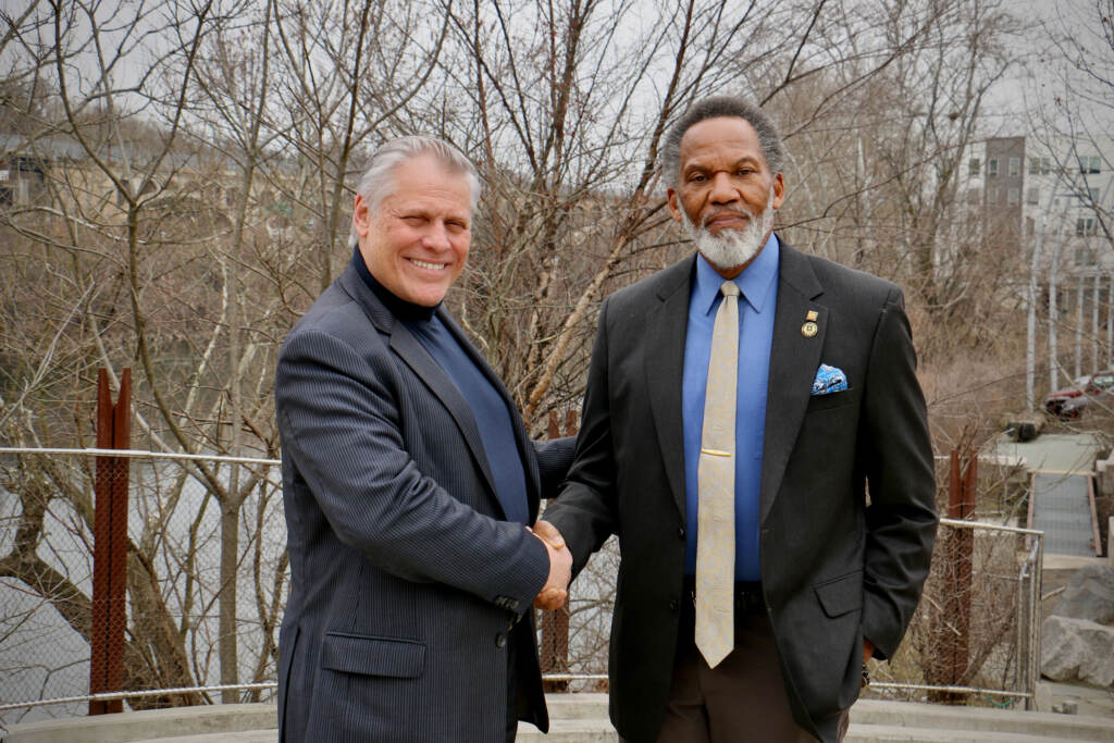 2023 02 16-e lee-brian evans kevin douglas greene-philadelphia manayunk venice island-forgotten founding fathers new freedom theater handshake Two men shake hands outdoors while posing for a photo.