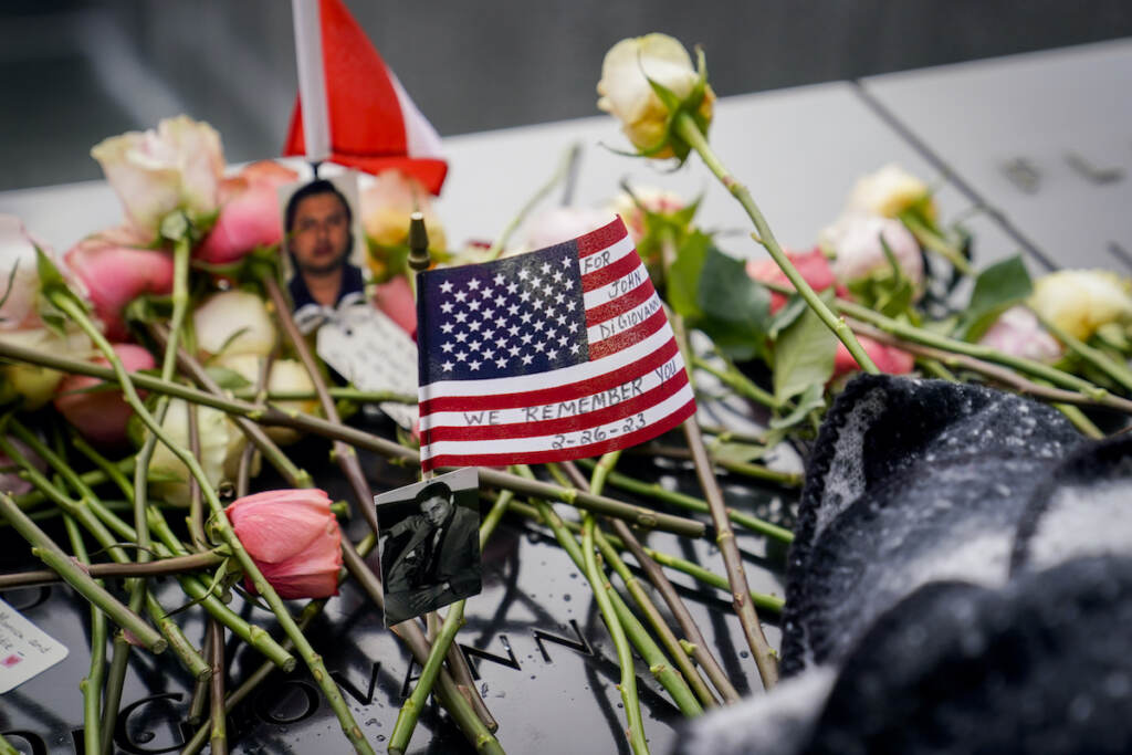Mourners place flowers over the names of the victims of the 1993 World Trade Center bombing during a ceremony at the 9/11 Memorial