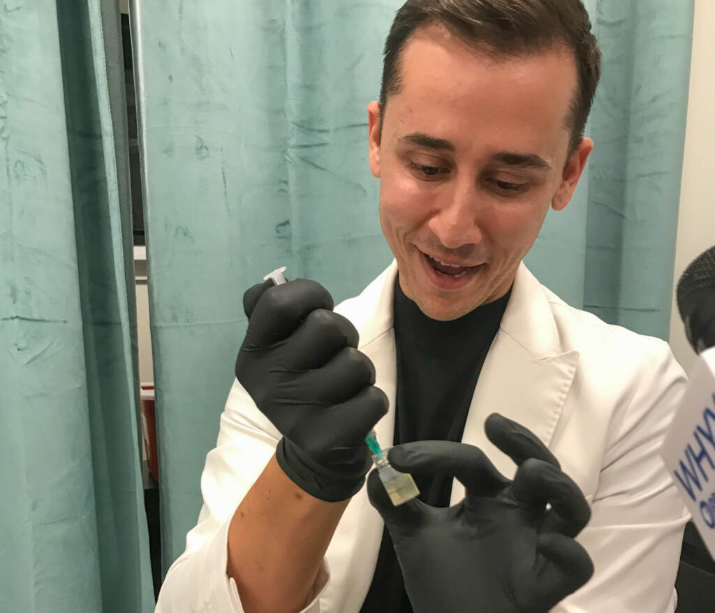Akis Ntonos, a family nurse practitioner specializing in aesthetic dermatology, draws a treatment based on stem cells from a vial into a syringe to prepare for a microneedling procedure.
