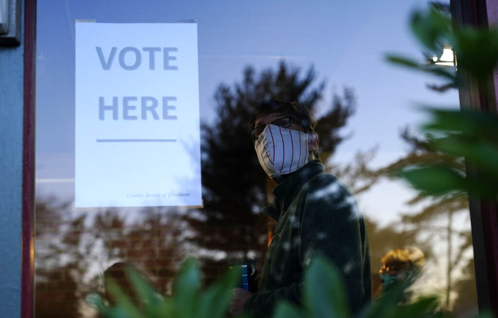 A voter lines up in a polling place to cast a ballot for the 2020 general election in Springfield, Pa., which is located in the Philadelphia suburb of Delaware County. Voter waiting in line at a polling place.