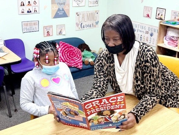 delaware-childcare-1 Melanie Price reads a book with a child in a classroom.