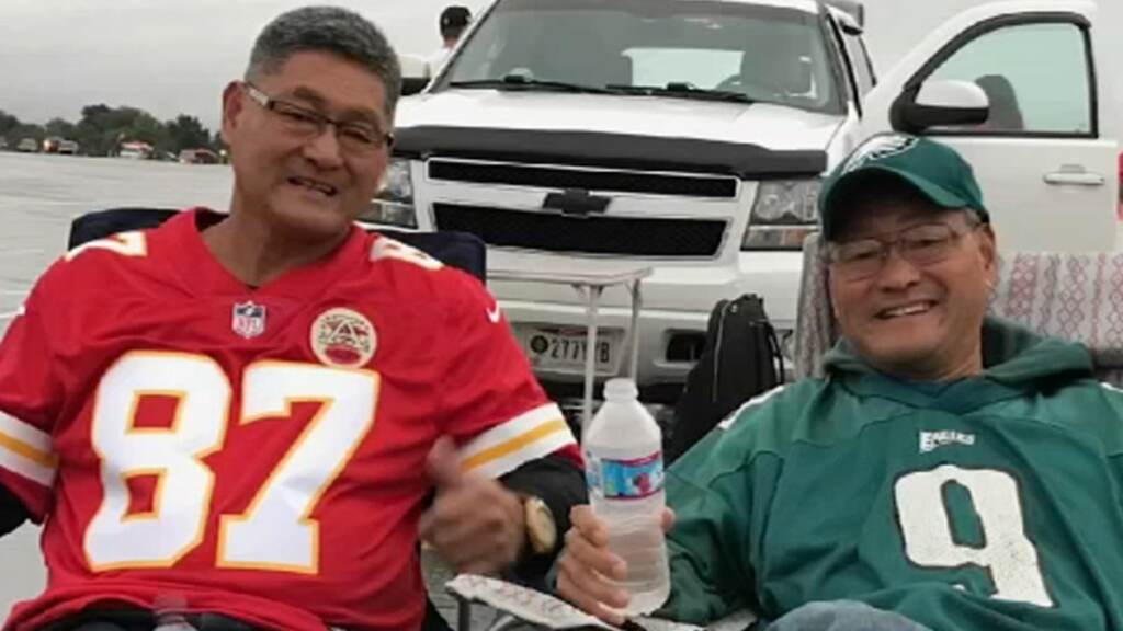 eagles-chiefs-fans-brothers Two brothers wearing Chiefs and Eagles jerseys, respectively, pose for a photo.