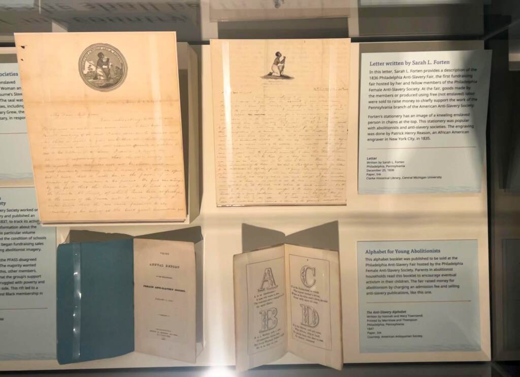 fortenfamily-blackfounders-amrevmuseum-04-scaled A close-up of papers underneath a display case.