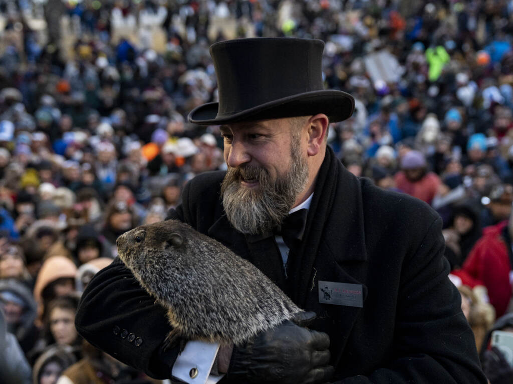 Groundhog handler AJ Derume stands in front of a crowd holding Punxsutawney Phil, who saw his shadow on Thursday to predict a late spring