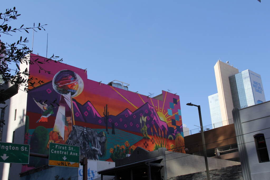 A mural of the Lombardi trophy is visible on the side of a building.