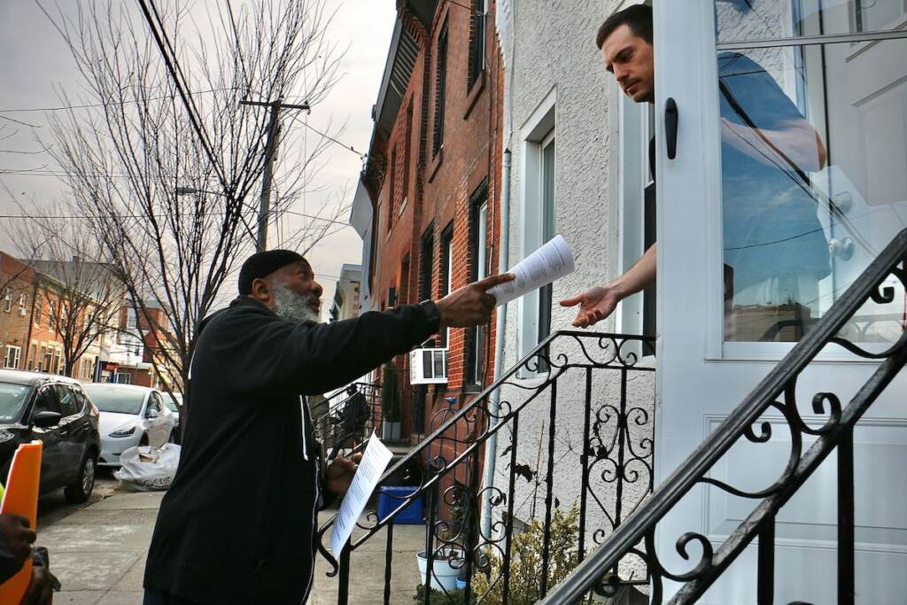 point-breeze-gun-violence-prevention-2 A person passes out a brochure to someone in a house.