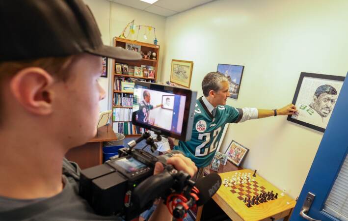 Auerbach shows off a framed print of Reggie White.  (Brandywine School District)