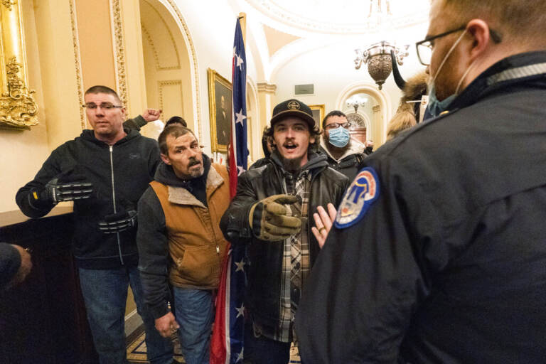 File photo: Kevin Seefried, second from left, holds a Confederate battle flag as he and other insurrectionists loyal to President Donald Trump are confronted by U.S. Capitol Police officers outside the Senate Chamber inside the Capitol in Washington, Jan. 6, 2021. A federal judge on Wednesday, June 15, 2022, convicted Kevin Seefried and his adult son Hunter Seefried of charges that they stormed the U.S. Capitol together to obstruct Congress from certifying President Joe Biden’s 2020 electoral victory. (AP Photo/Manuel Balce Ceneta, File)