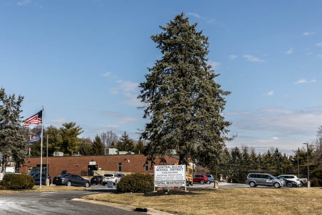 Central Bucks School District headquarters (Kimberly Paynter/WHYY) A building seen from the distance on a sunny day.