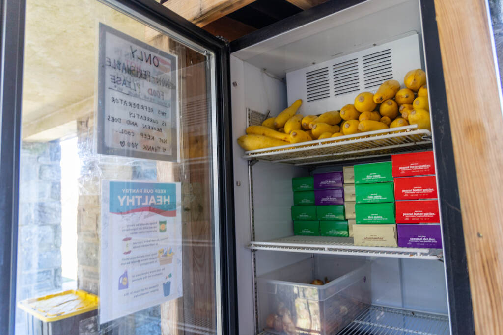 A close-up of boxes of cookies and produce in a refrigerator.