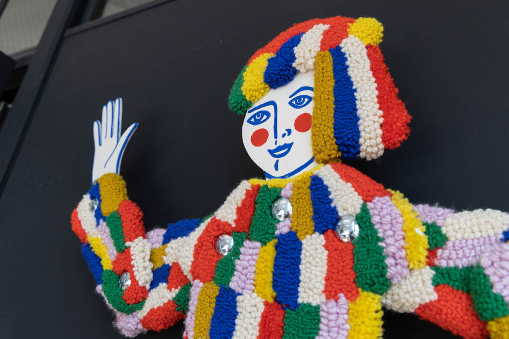 03 23 2023 k paynter tuft the world artwork insert A tufted carnival figure is shown.