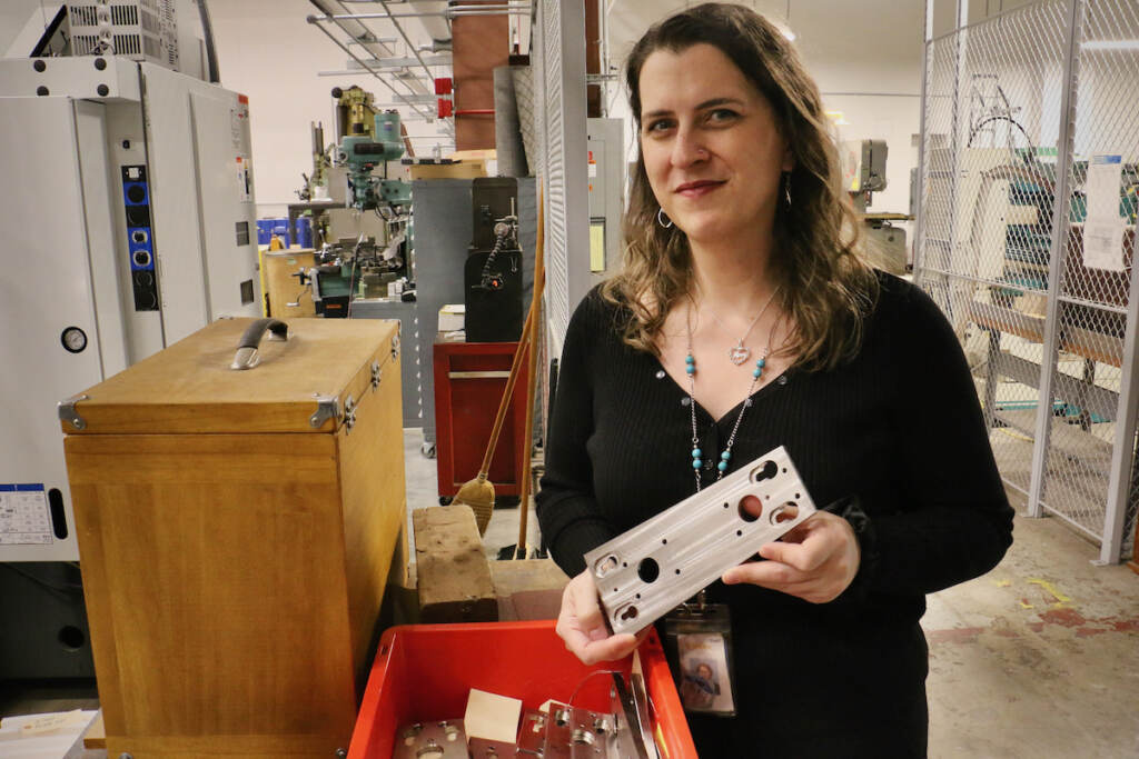Fabrication shop supervisor Morgan Styer holds one of the stainless steel transition plates that will line the vacuum vessel and the center stack.