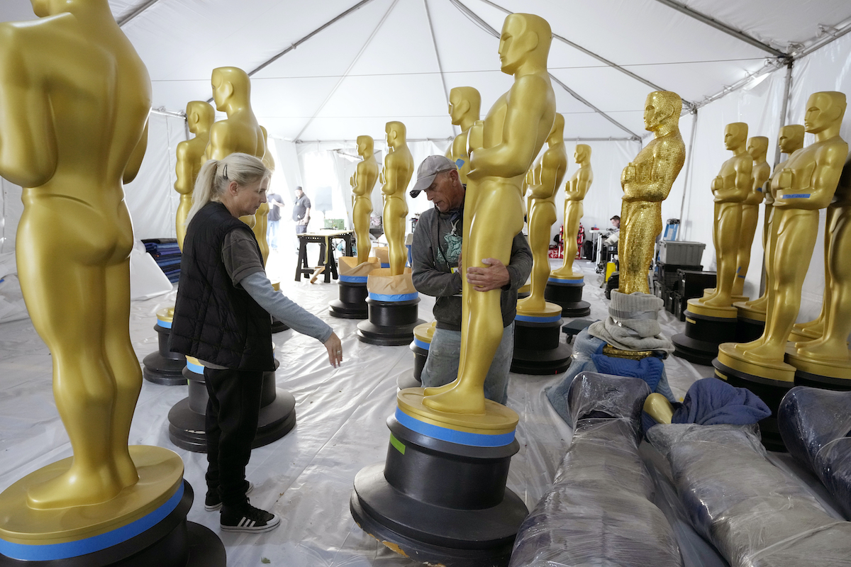Antje Menikheim (left) lead scenic painter for Sunday's 95th Academy Awards, and scenic artist Michael Thomas prepare Oscar statues for the event, Wednesday, March 8, 2023, near the Dolby Theatre in Los Angeles