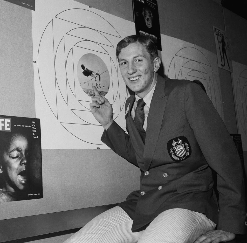 Dick Fosbury, who won a gold medal at the 1968 Olympic games in Mexico city with an Unorthodox jumping style, is shown on Jan. 6, 1969 in New York City with a photo of himself using the style, Known as the ''Fosbury Flop.'' Fosbury goes over the bar backwards while the standard way is to go over face down with the body parallel to the bar