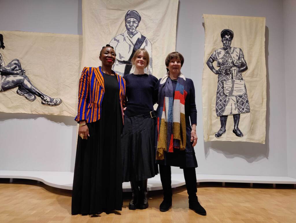 (From left) Artist Lebohang Kganye, curator Emma Lewis, and artist Sue Williams stand in front of Kganye’s large-scale fabric patchwork portraits of her matriarchal relatives, in ''Tell Me What You Remember'' at the Barnes Foundation