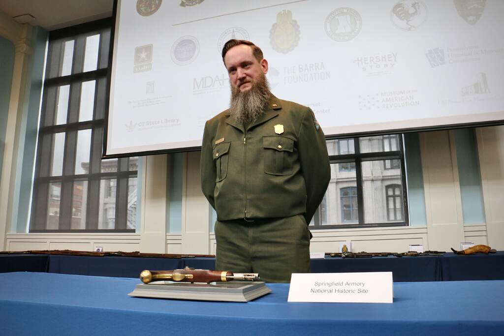 Alex MacKenzie of Springfield Armory National Historic Site poses with a pistol stolen 50 years ago and returned during a repatriation ceremony at the Museum of the American Revolution