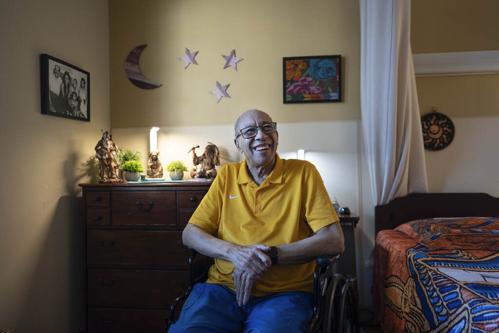 Nursing Homes Living in Poverty Alex Morisey sits in his wheelchair in his room, smiling.