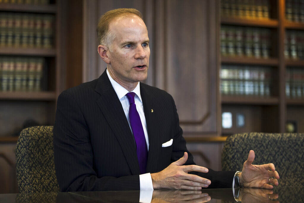 Bill McSwain speaks while seated at a table, gesturing with his hands.