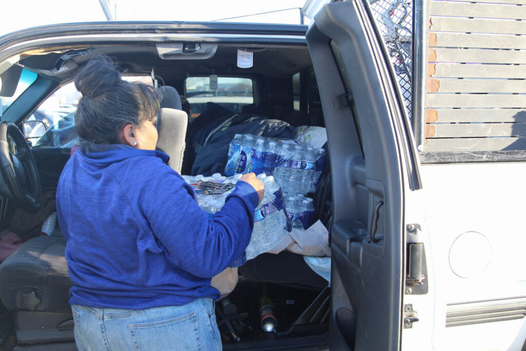 bottledwatershoppingrush-08 someone loading bottles of water into their car