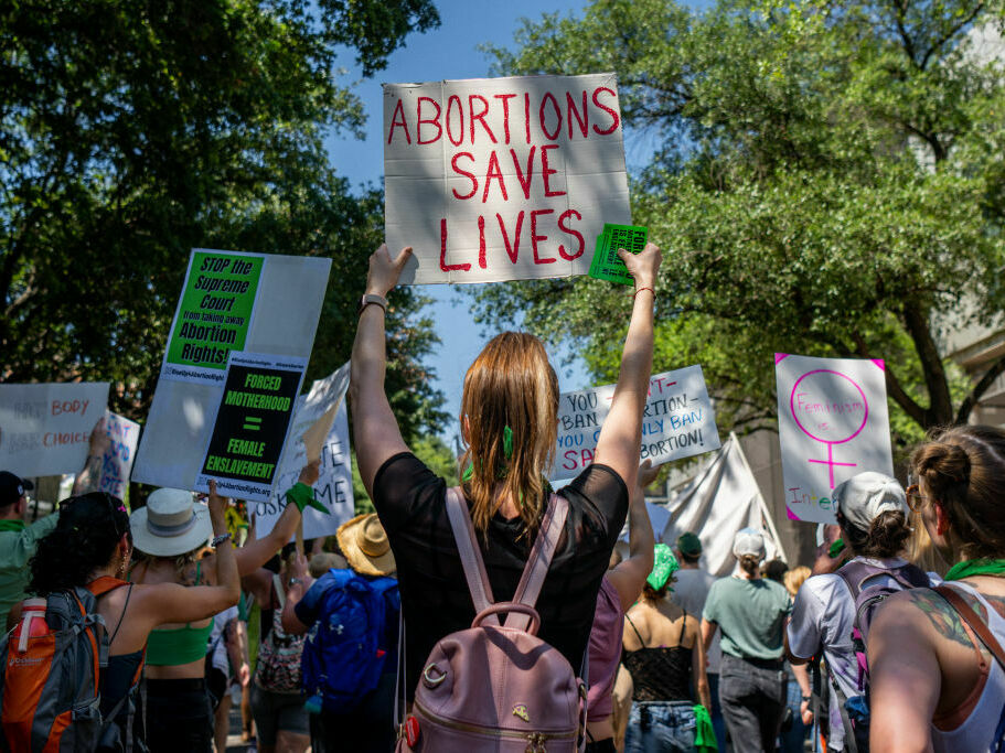 Texas abortion rights supporters march near the Austin Convention Center in May of 2022. A new lawsuit filed in state court asks a judge to clarify medical exemptions in the state's abortion bans. (Brandon Bell/Getty Images)