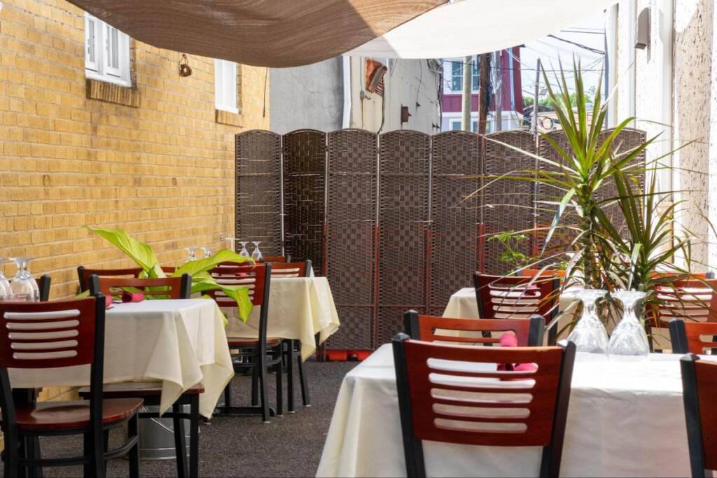 Tables and chairs are arranged on a restaurant's outdoor patio.