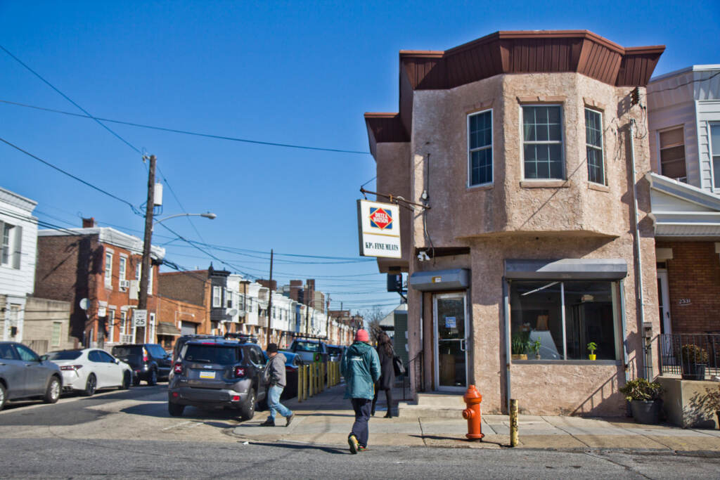 kpsmeats-butchershop-portrichmond-01 People walk on a street in Philadelphia on a sunny day.