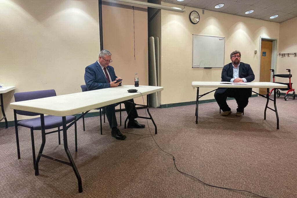 mercer-county-executive-debate-k-burns-2023-03-02 Asm. Dan Benson (left), who is running for Mercer County Executive, preparing for a candidate forum Tuesday in West Windsor, N.J. The empty chair to his right was reserved for incumbent Brian Hughes. But Hughes withdrew from the event the night before. (P. Kenneth Burns/WHYY)