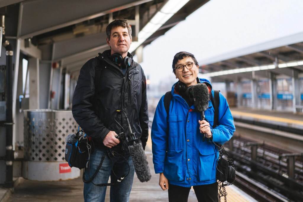 John Myers, left, stands next to Alex Lewis, right. They're on a MFL elevated platform, and the train tracks are visible behind them.