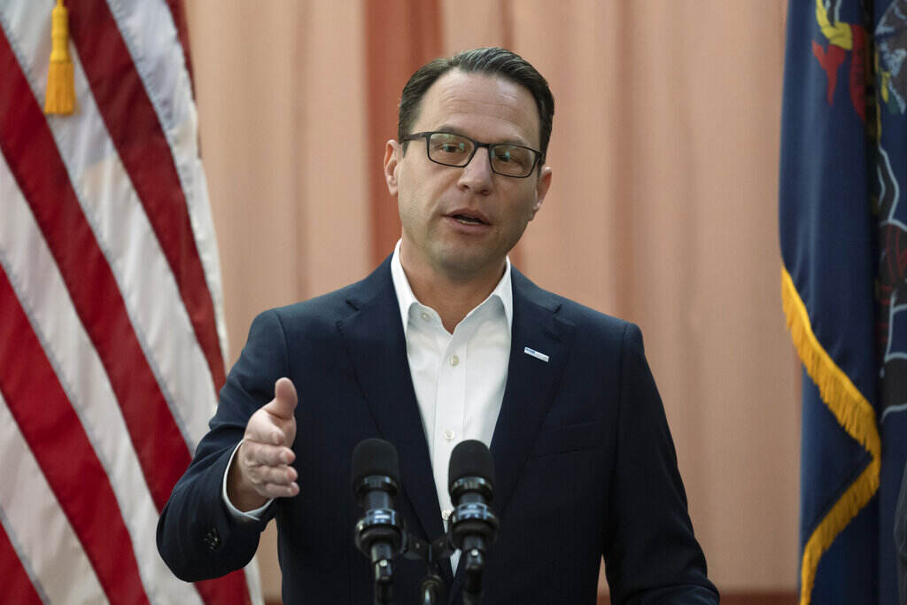 Gov. Josh Shapiro gestures as he speaks at a podium.