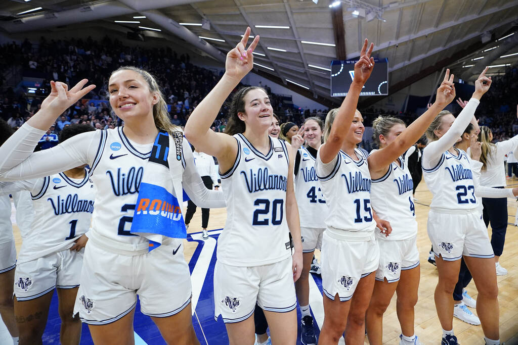 NCAA Cleveland St Villanova Basketball Villanova players stand together, arms upraised, celebrating after a victory.