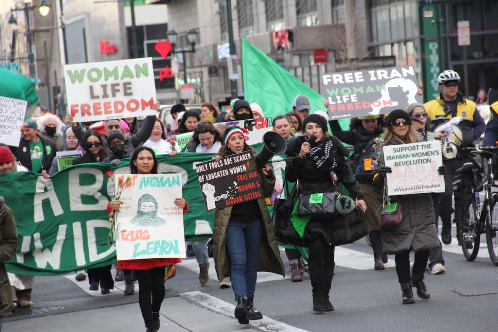 womens-day-protest-philly-1 A group of people march down a street in a protest for women's rights in Iran and Afghanistan and abortion rights in the U.S.