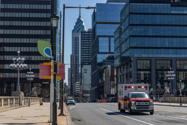 An ambulance driving on a major road in Philly.