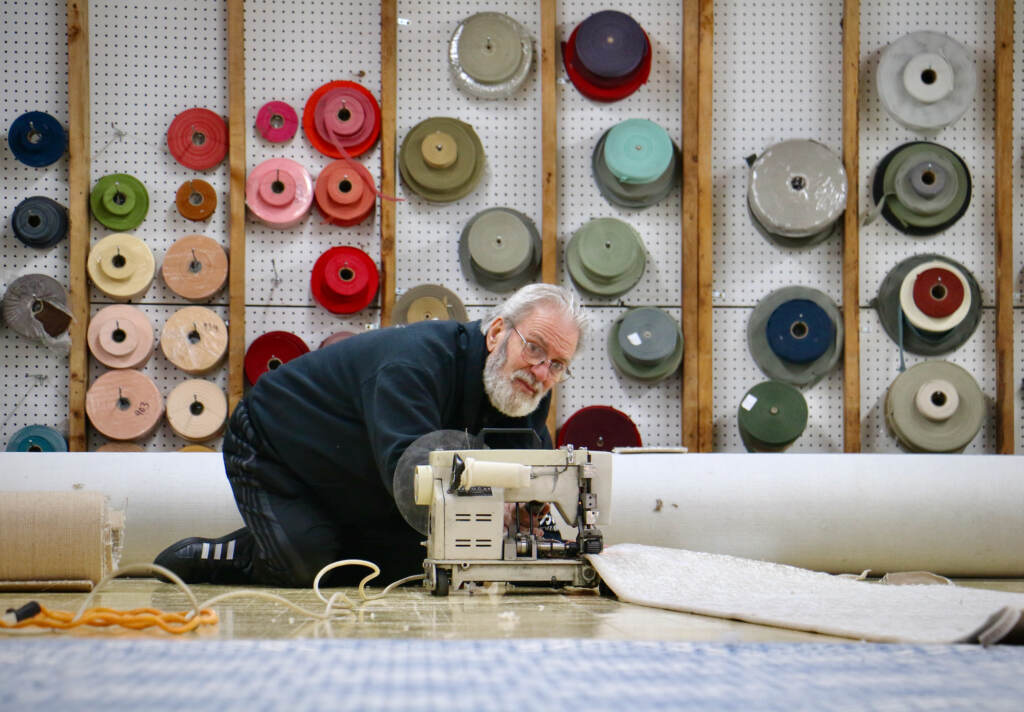 Jerry Amadio on the floor working on a carpet