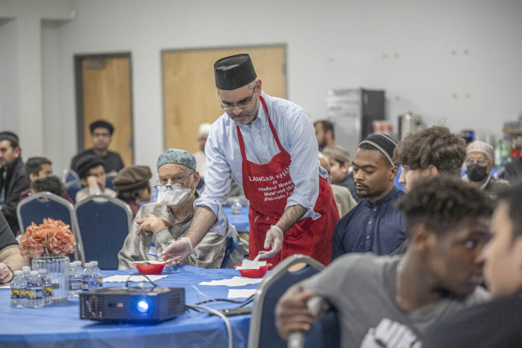 IFTAR Madeel Abdullah, President National President, Ahmadiyya Muslim Youth Association serves participants small dishes of dates and spicy chickpeas which are eaten as part of breaking the fast during an Interfaith Iftar at the Baitul Aafiyat Mosque
