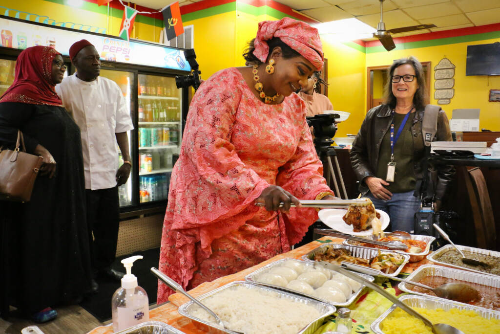 2023 04 10-e lee-youma ba-philadelphia woodland avenue-africatown restaurant week buffet Youma Ba prepares a plate for guests at the launch of Africatown Restaurant Week at the African Small Pot Restaurant on Woodland Avenue