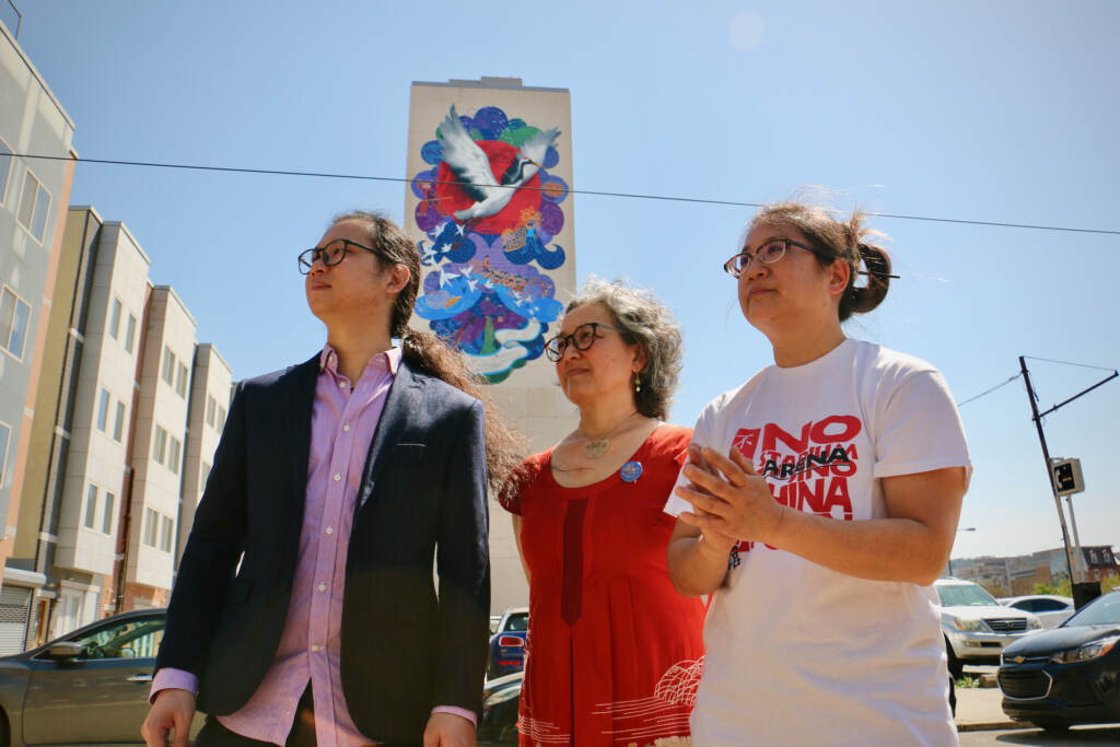Chenlin Cai, Eurhi Jones, and Yvonne Lung pose in front of a mural they created.